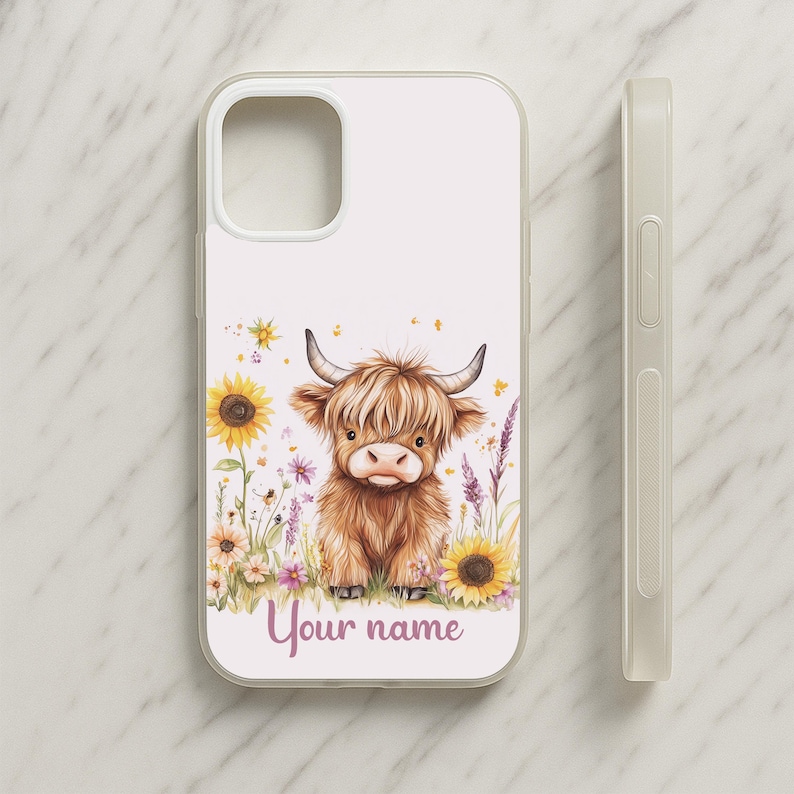 May include: A white phone case featuring a watercolor illustration of a Highland cow in a field of sunflowers and wildflowers. The text "Your name" is written in a cursive font at the bottom of the case. A matching white phone case is shown next to the case.