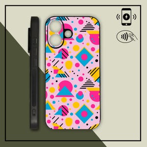 May include: A pink phone case with a colorful geometric pattern. The design includes blue, yellow, and pink shapes, including triangles, circles, and squares. A black phone case is shown next to the patterned case. The phone case is designed for wireless charging.