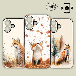May include: Three phone cases with watercolor fox designs. The cases feature a cream background with images of foxes in a forest setting, with falling leaves. The cases are designed for wireless charging.