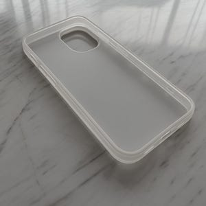 May include: A clear, frosted plastic phone case. The case has a rectangular shape with rounded corners and cutouts for the camera and buttons. The case is designed to protect a smartphone.