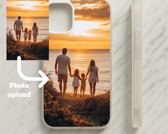Op de afbeelding: Transparante telefoonhoes met een aangepaste foto van een gezin op een strand bij zonsondergang. De hoes heeft een witte rand en de tekst "Custom made phone case" staat onderaan. Een kleinere afbeelding van de foto staat in de linkerbovenhoek met "Photo upload".