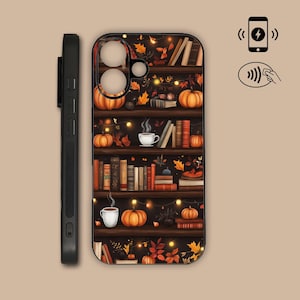 May include: A black smartphone case featuring a bookshelf design with orange pumpkins, stacks of books, steaming white mugs, and autumn leaves. The case includes cutouts for the camera lens and side buttons, with icons indicating wireless charging.