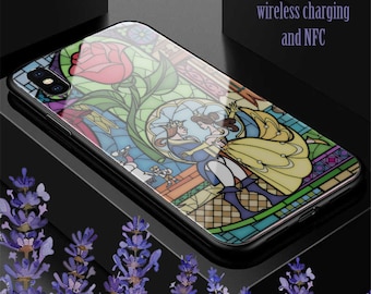 May include: A clear phone case featuring a stained glass design of Belle and the Beast from Beauty and the Beast. The case is compatible with wireless charging and NFC.