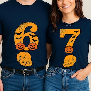 May include: Navy blue t-shirts with Halloween-themed designs. One shirt features a large orange number 6 with bats, a spiderweb, pumpkins, and a hand. The other shirt has a number 7 with similar Halloween elements.