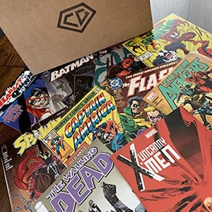 May include: A cardboard box filled with various comic books, including Batman, Captain America, The Walking Dead, and The Flash. The box is open and the comics are spilling out.