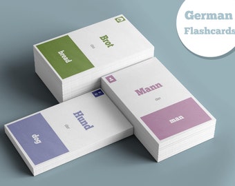 May include: A set of German flashcards with the words "bread", "man", and "dog" written in English and German. The cards are stacked on a light blue surface.