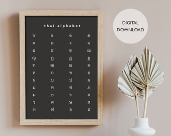 May include: A framed black and white printable poster with the Thai alphabet written in white text. The poster is hanging on a light brown wall. The text "thai alphabet" and "DIGITAL DOWNLOAD" are also visible in the image.