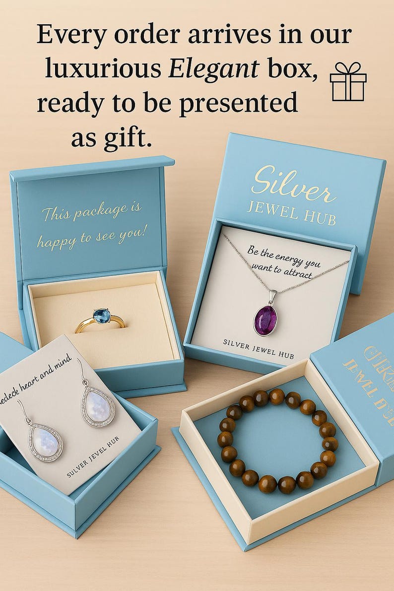 May include: Four light blue jewelry boxes containing a gold ring with a blue stone, a silver necklace with a purple pendant, silver teardrop earrings with iridescent stones, and a brown beaded bracelet, with text printed on the boxes and cards.