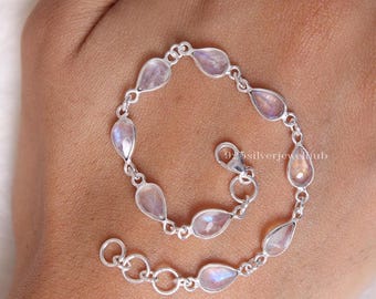 May include: A silver chain bracelet featuring multiple teardrop-shaped moonstone gems linked together. The bracelet includes a lobster claw clasp and an adjustable extender chain with circular links. The metal has a polished finish.