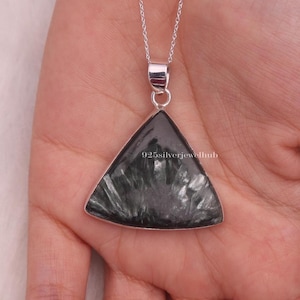 May include: A triangular pendant featuring a dark gray stone with a radiating fibrous pattern, set in a polished silver frame. The pendant hangs from a delicate silver chain. The text 925silverjewelhub is visible on the stone surface.