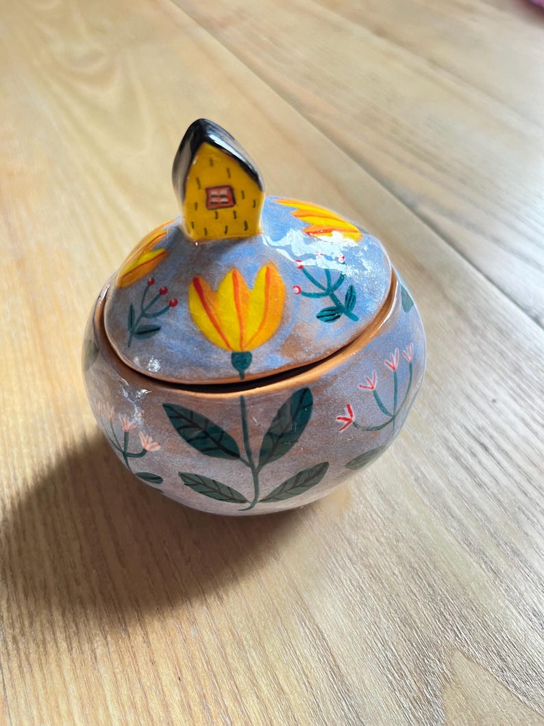 Light Blue Round Keepsake Box With Yellow Flowers and a Tiny House