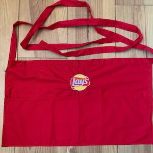 May include: Red apron with two pockets and a Lay's potato chips logo embroidered on the front.