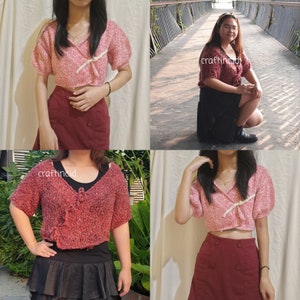 May include: A pink and white knitted crop top with a tie detail. The top is shown being worn with a burgundy skirt.