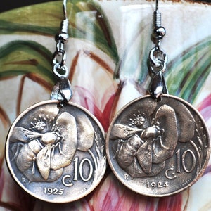 May include: A pair of earrings made from vintage Italian coins featuring a bee and flower design. The coins are dated 1924 and 1925 and have the inscription "C. 10" on them.
