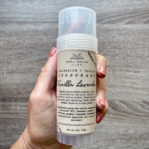 May include: A white deodorant stick with a brown label that reads "Maple Hollow Farm Magnesium + Tallow Deodorant Vanilla Lavender". The label also includes a list of ingredients and instructions for use. The stick is 2 oz (57g).