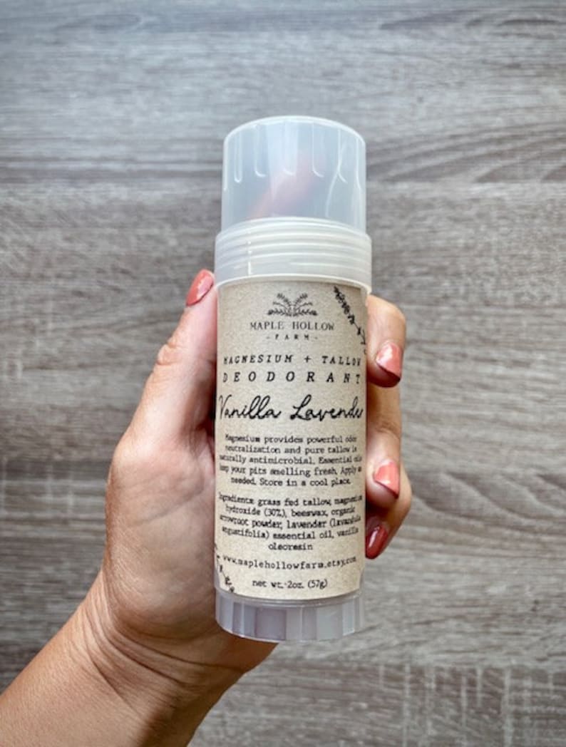 May include: A white deodorant stick with a brown label that reads "Maple Hollow Farm Magnesium + Tallow Deodorant Vanilla Lavender". The label also includes a list of ingredients and instructions for use. The stick is 2 oz (57g).