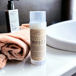 May include: A white deodorant stick with a brown label that reads "Maple Hollow Farm Magnesium + Tallow Deodorant Tamber Cedarwood + Palo Santo". The label also includes the ingredients and website address. The stick is 2 oz (57g).