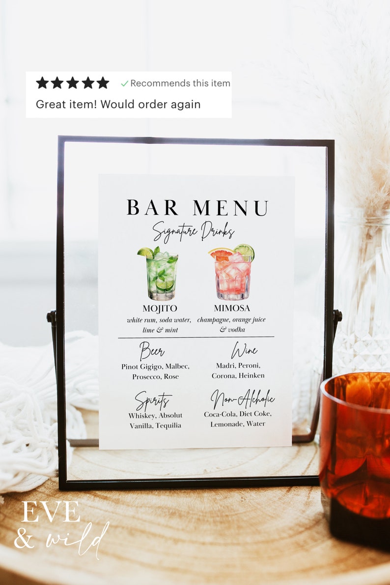 Op de afbeelding: Een zwart-witte barmenu-bord met de tekst "BAR MENU" en "Signature Drinks". Het menu bevat dranken zoals Mojito, Mimosa, bier, wijn, sterke drank en alcoholvrije dranken. Het bord bevat ook de tekst "EVE & wild".