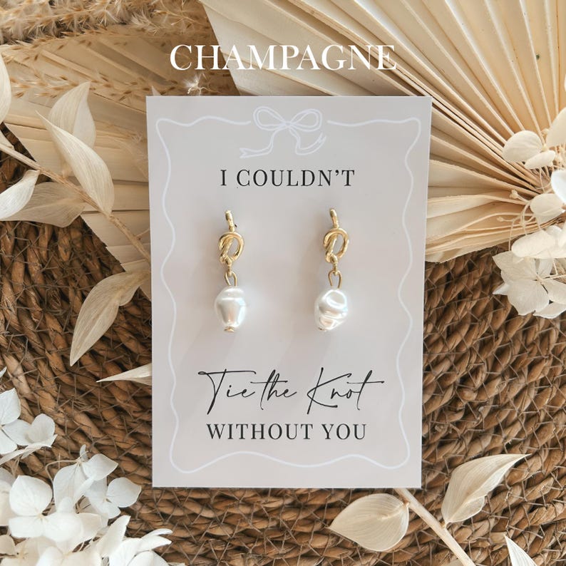 Pearl bridesmaid proposal earrings displayed on a champagne coloured proposal card, elegant wedding bridesmaid gift for maid of honour or bridal party proposal with a soft neutral aesthetic