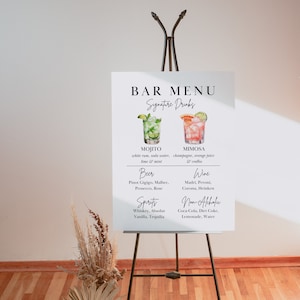 Op de afbeelding: Een wit bord met zwarte tekst op een ezel, met een barmenu met signature drinks, bier, wijn, sterke drank en alcoholvrije opties. De dranken zijn ge&iuml;llustreerd met aquarelbeelden van cocktails.