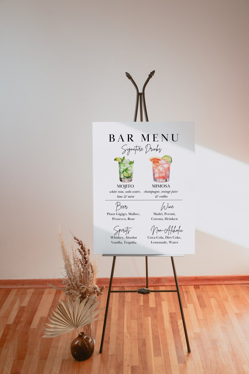 Op de afbeelding: Een wit bord met zwarte tekst op een ezel, met een barmenu met signature drinks, bier, wijn, sterke drank en alcoholvrije opties. De dranken zijn ge&iuml;llustreerd met aquarelbeelden van cocktails.