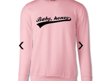 May include: A pink long-sleeved sweatshirt with a black graphic that says "Baby, honey" in a vintage baseball font.