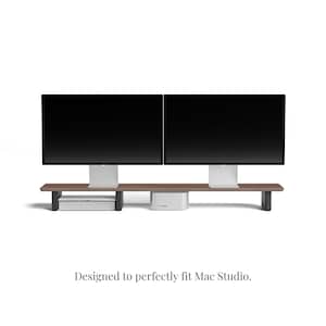 K&ouml;nnte beinhalten: Ein Holzst&auml;nder mit zwei Ablagen, der f&uuml;r zwei Computermonitore und einen Mac Studio-Computer ausgelegt ist. Der St&auml;nder ist aus dunklem Holz gefertigt und hat ein modernes Design.