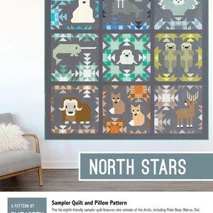 May include: A gray quilt with nine square blocks, each featuring a different Arctic animal in a geometric design. Animals include a polar bear, walrus, owl, narwhal, seal, otter, muskox, fox, and reindeer. The text "NORTH STARS" is displayed below the quilt.