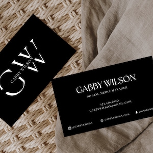 May include: Black and white business card with the name Gabby Wilson and the title Social Media Manager. The card also includes contact information such as a phone number, email address, and social media handles.