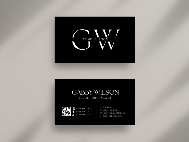 May include: Black and white business card with the initials "GW" and the name "Gabby Wilson" in a serif font. The card also includes the title "Social Media Manager" and contact information, including a QR code, website, email address, and physical address.