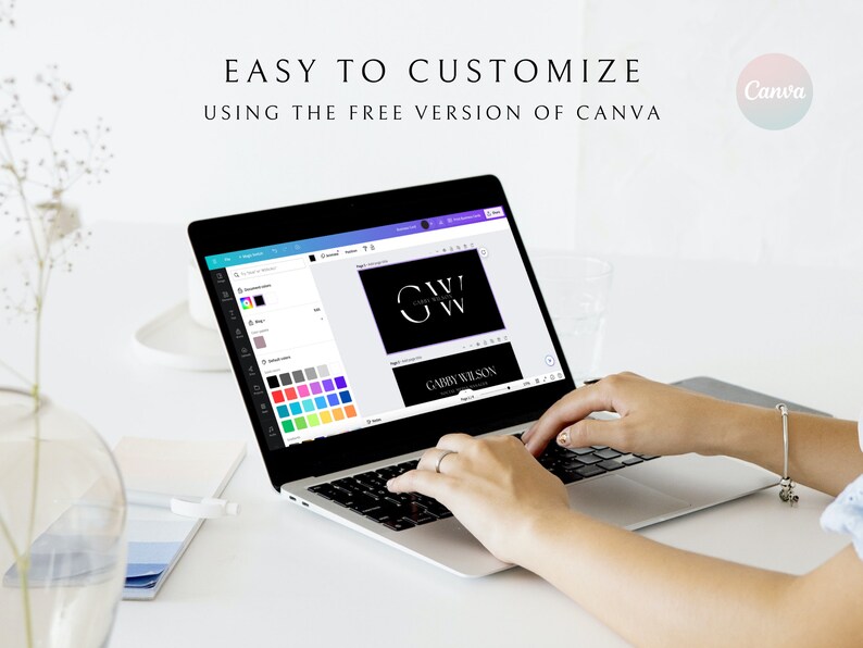 May include: A laptop screen shows a Canva design with a black background and white text that reads "G.A.W.V. GABBY WILSON". The screen shows a color palette with various shades of blue, green, purple, and gray. The laptop is on a white desk with a person's hands typing on the keyboard.