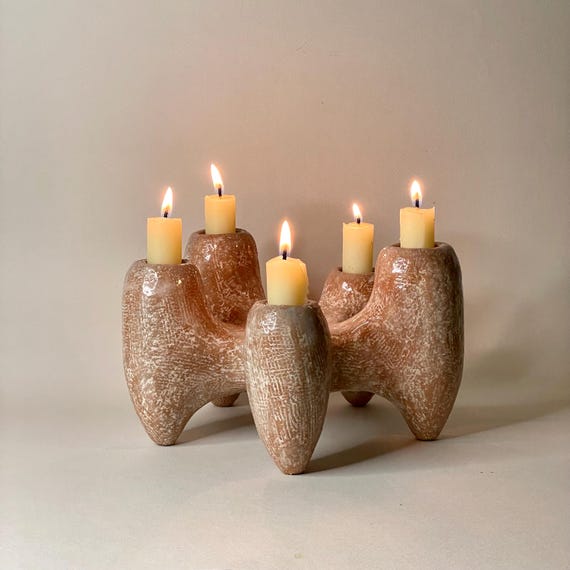 A sculptural ceramic candelabra that looks like it belongs in a modernist gallery — organic, hand-formed arms hold candles in a way no factory mold ever could.