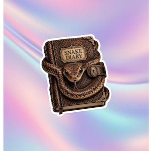 May include: A brown leather-textured diary with a snake coiled around the cover. The book features a gold-coloured plaque with the text SNAKE DIARY, metal corner protectors, and a small lock mechanism. The snake has detailed scales and a visible tongue.