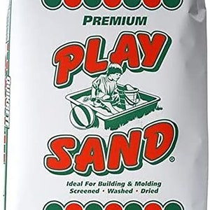 May include: A white bag of Quikrete Premium Play Sand. The bag features a green and red logo with the words "Quikrete" and "Play Sand". The bag also includes a picture of a child playing in a sandbox. The bag is labeled "Net Wt. 50 lb Approx 1/2 Cu. Ft. (22.7kg)".
