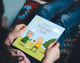 May include: A personalized children's book with a light blue cover featuring illustrations of an elderly couple. The title reads "The Story of... INSERT NAME & NAME" with a sunny sky background. The book is held by a person wearing blue jeans.