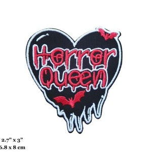 Puede incluir: Parche negro en forma de corazón con bordes blancos que gotean. El parche presenta el texto "Horror Queen" en rojo con contornos blancos. También se incluyen dos murciélagos rojos en el parche.