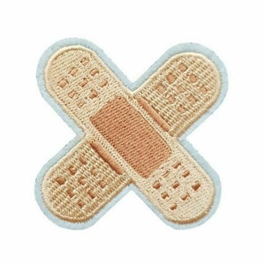 May include: A light blue embroidered patch shaped like a bandage with a brown center. The patch is a cute and whimsical design.