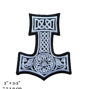 Könnte beinhalten: Weiß gestickter Mjolnir-Hammer-Patch mit schwarzem Hintergrund und keltischen Knotendesigns. Der Patch misst 7,5 cm x 9 cm.