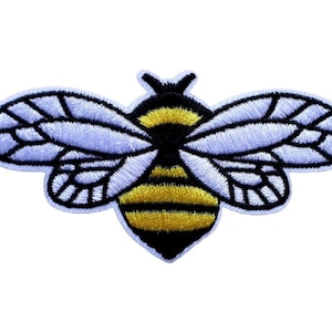 Könnte beinhalten: Ein gestickter Bienen-Patch in Schwarz und Gelb mit weißen Flügeln. Der Patch ist 3,5 Zoll mal 1,75 Zoll groß und misst 9 cm mal 4,5 cm.