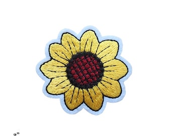 Pode incluir: Um remendo bordado de girassol amarelo com um centro vermelho. O remendo tem 5 cm de diâmetro.