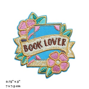 Puede incluir: Un parche bordado para planchar con un libro azul, una pancarta que dice "BOOK LOVER" y flores rosas y verdes. El parche mide 7 cm por 7,5 cm.