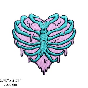 May include: Embroidered patch in the shape of a heart, featuring a teal rib cage design over a light purple background. The patch measures 2.75" x 2.75".