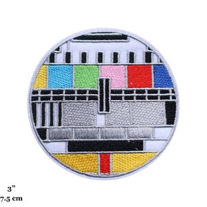 Peut inclure: Un patch rond brodé représentant un motif de test de télévision classique avec des barres colorées et une grille grise et noire. Le patch mesure 7,5 cm de diamètre.
