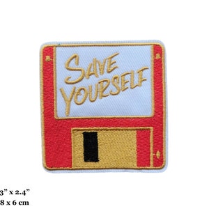 May include: A red and gold embroidered iron-on patch with a floppy disk design. The text "SAVE YOURSELF" is written in gold on the white floppy disk.
