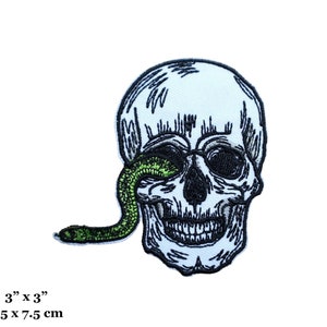 May include: A white embroidered skull with a green snake coming out of its eye socket. The skull is smiling and has a black outline. The snake is green with a black outline. The patch is 3 inches by 3 inches.