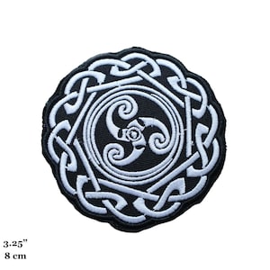 May include: A white embroidered Celtic knot design on a black background. The design features a triple spiral in the center. The patch is 3.25 inches in diameter.
