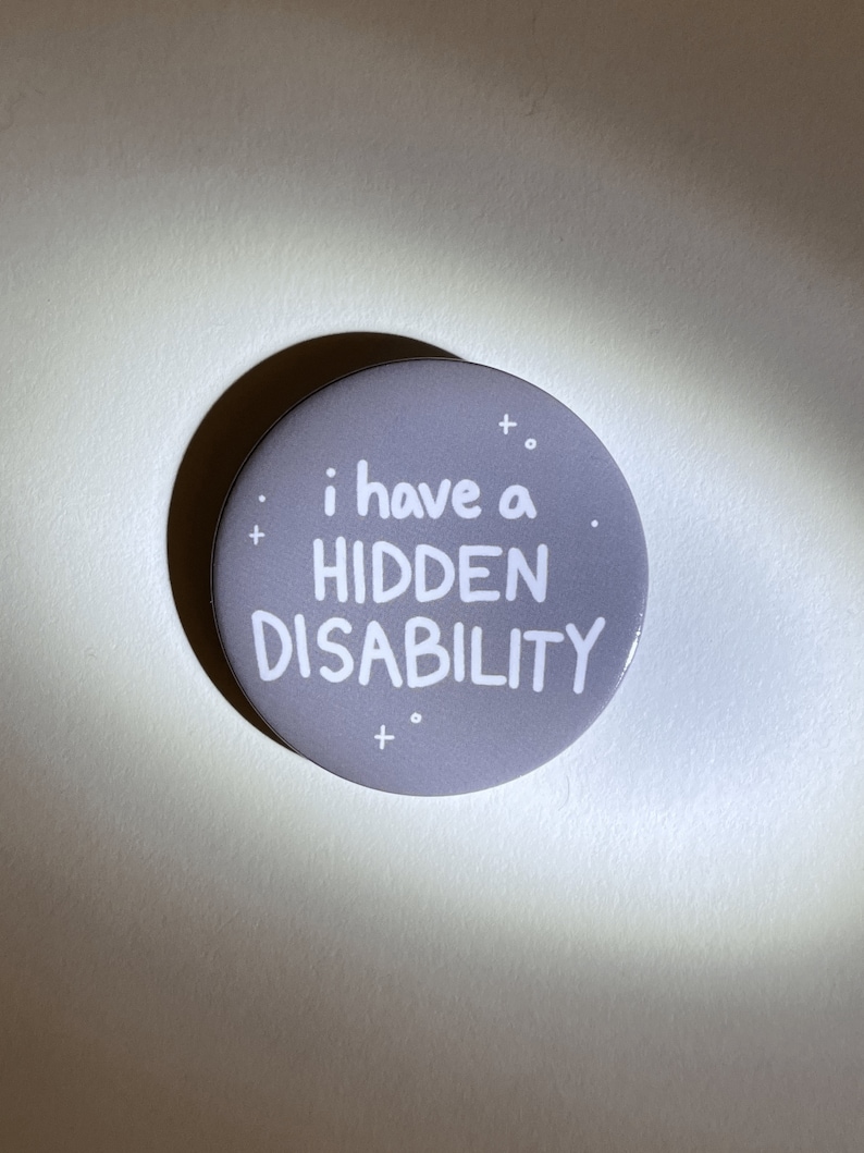 Puede incluir: Un bot&oacute;n gris con texto blanco que dice "i have a HIDDEN DISABILITY".