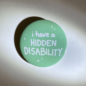 Puede incluir: Un bot&oacute;n verde con texto blanco que dice "i have a HIDDEN DISABILITY".