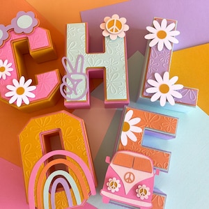 Può includere: Lettere di carta colorate che compongono la parola "CHLOE" con un segno di pace e accenti floreali. Le lettere sono sovrapposte e hanno un effetto 3D. La lettera "O" ha un arcobaleno all'interno.