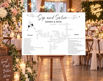 May include: A white rectangular wedding crossword puzzle sign titled Sip and Solve with the names Sarah and Nick and the date 11-14-20. The sign features black text, a crossword grid, and a line drawing of two champagne glasses with hearts.